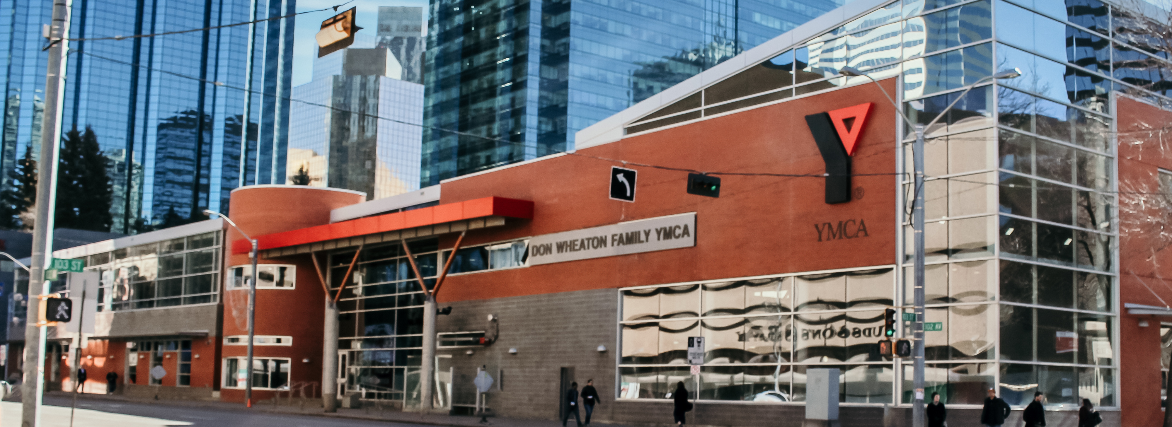 A brick building sits in the middle of high-rises in a downtown centre.