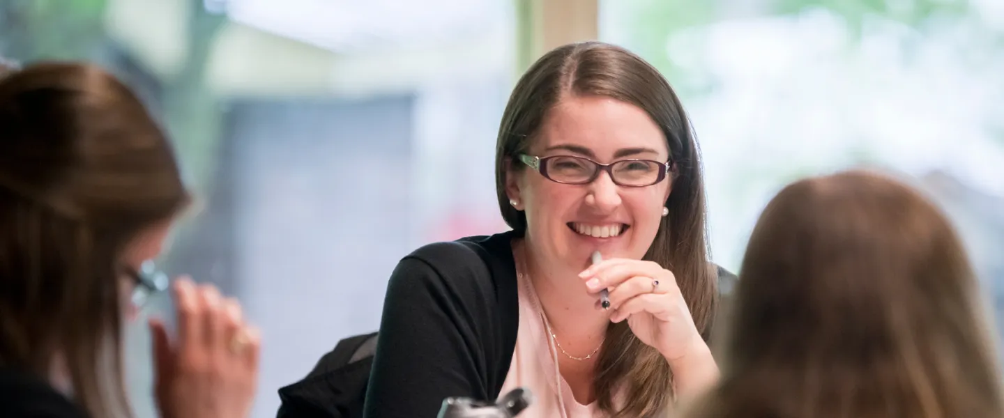 A group of women sit together at a table indoors.