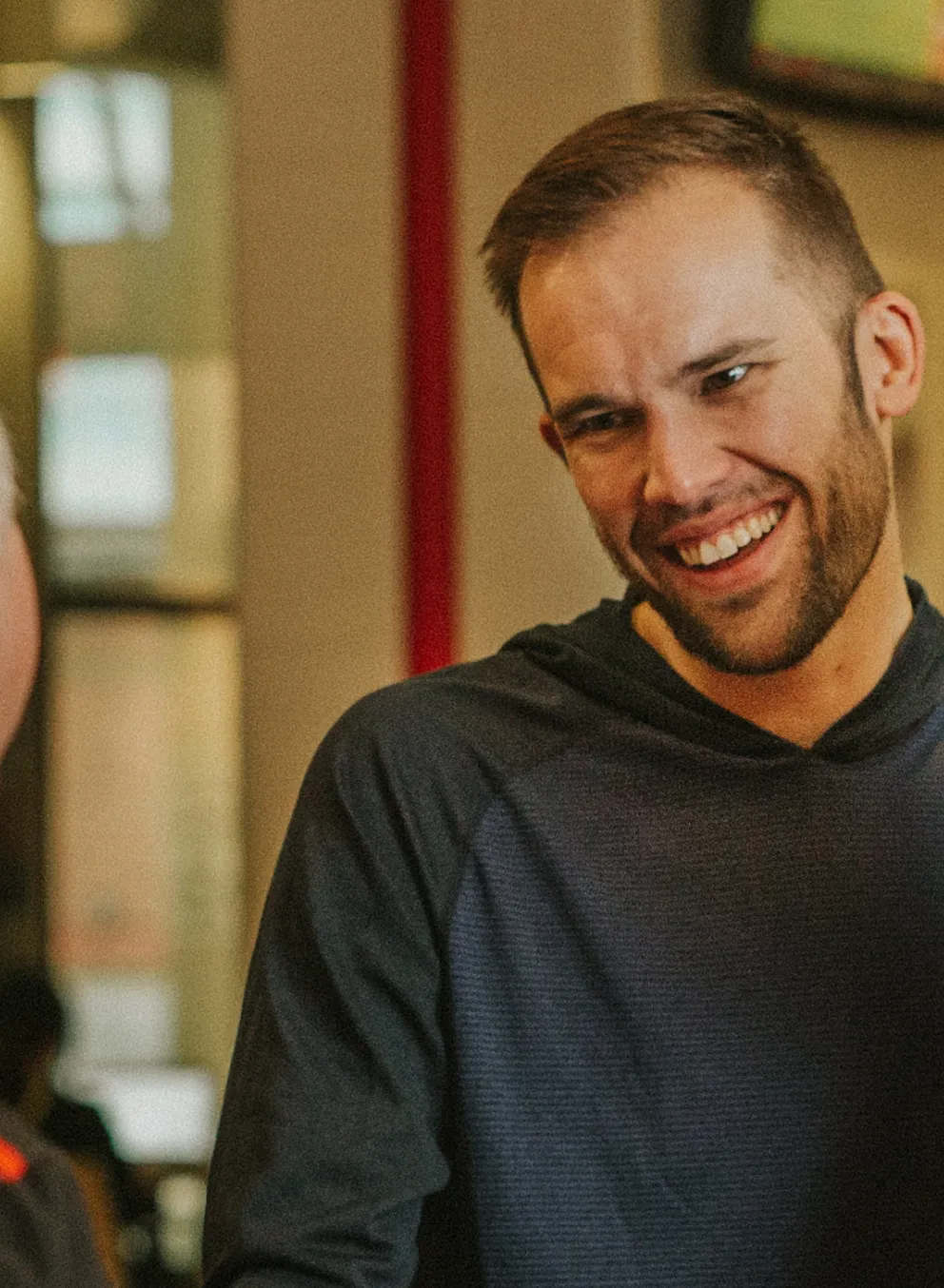 Two men standing at a YMCA front desk, talking to a YMCA staff member.