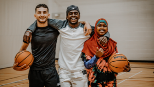 Happy people posing with basketballs.