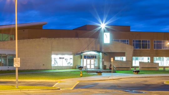 The interior lights of YMCA building shine bright at dusk.