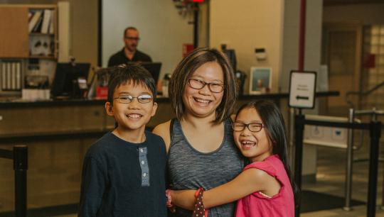 Mother, son and daughter standing together in a YMCA lobby
