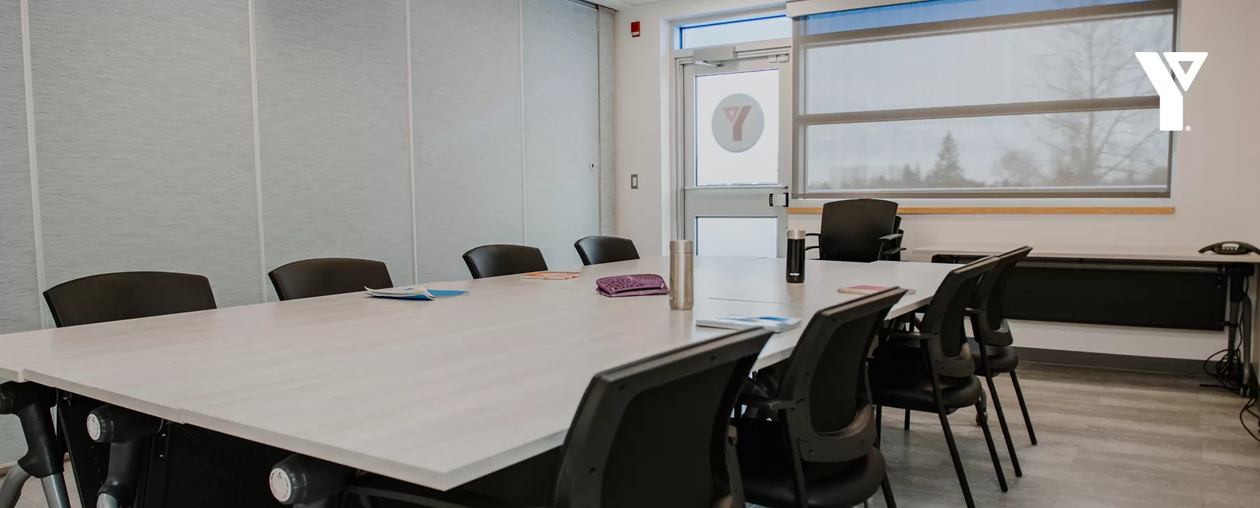 A small room featuring a boardroom-style table in the centre.