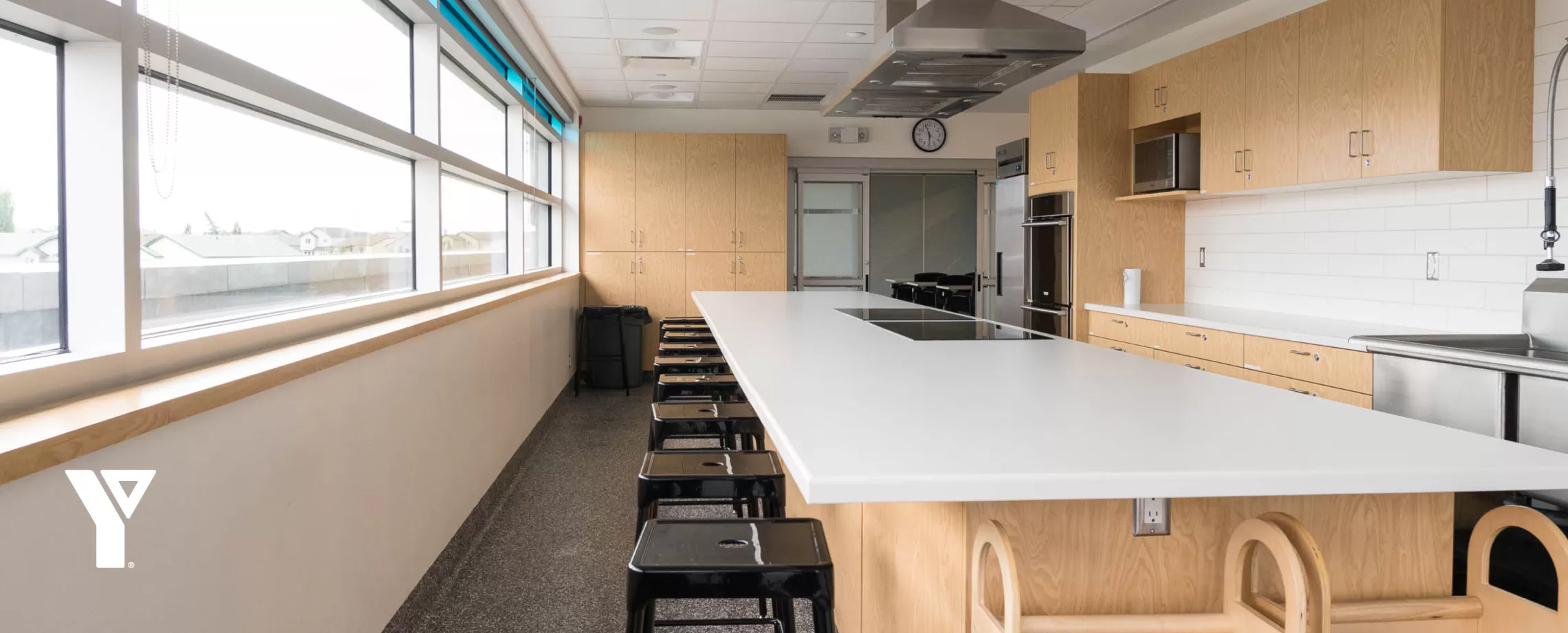 A state-of-the-art kitchen features a large kitchen island with stools around it, as well as other various kitchen gadgets.