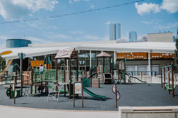 Boyle Street Plaza playground. Child on playground bridge. Playground features slides. 