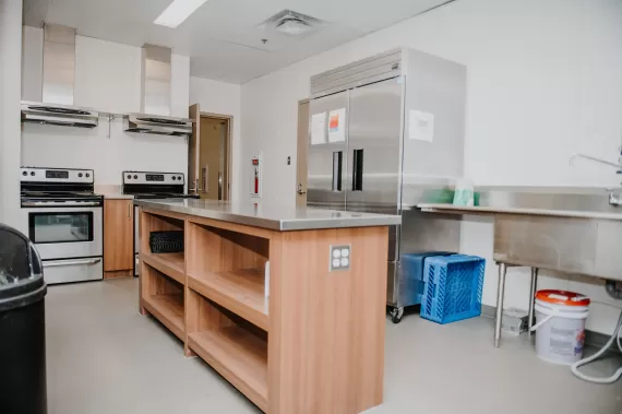 kitchen with two stoves, a large sink , island and trash can